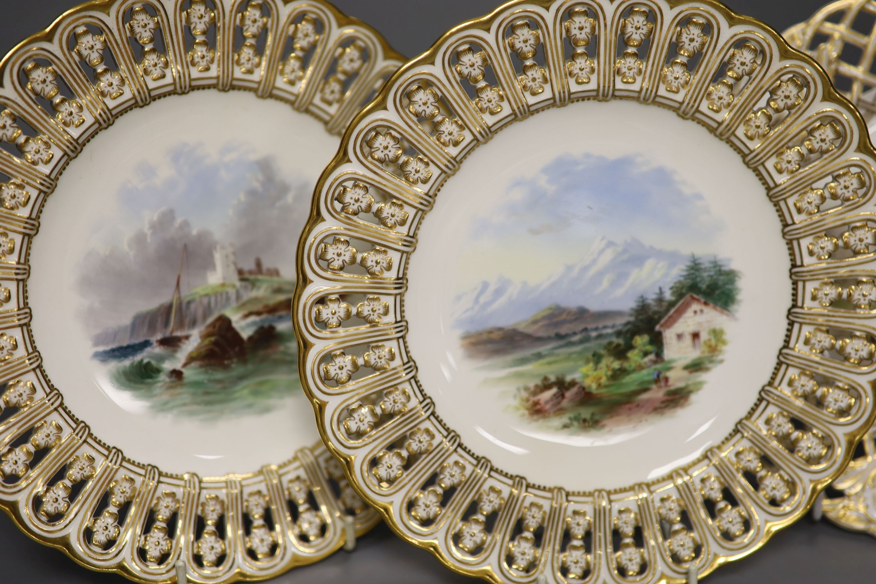 A pair of 19th century Minton pierced plates painted with landscapes, impressed marks, diameter 23cm, and a lattice work pierced plate